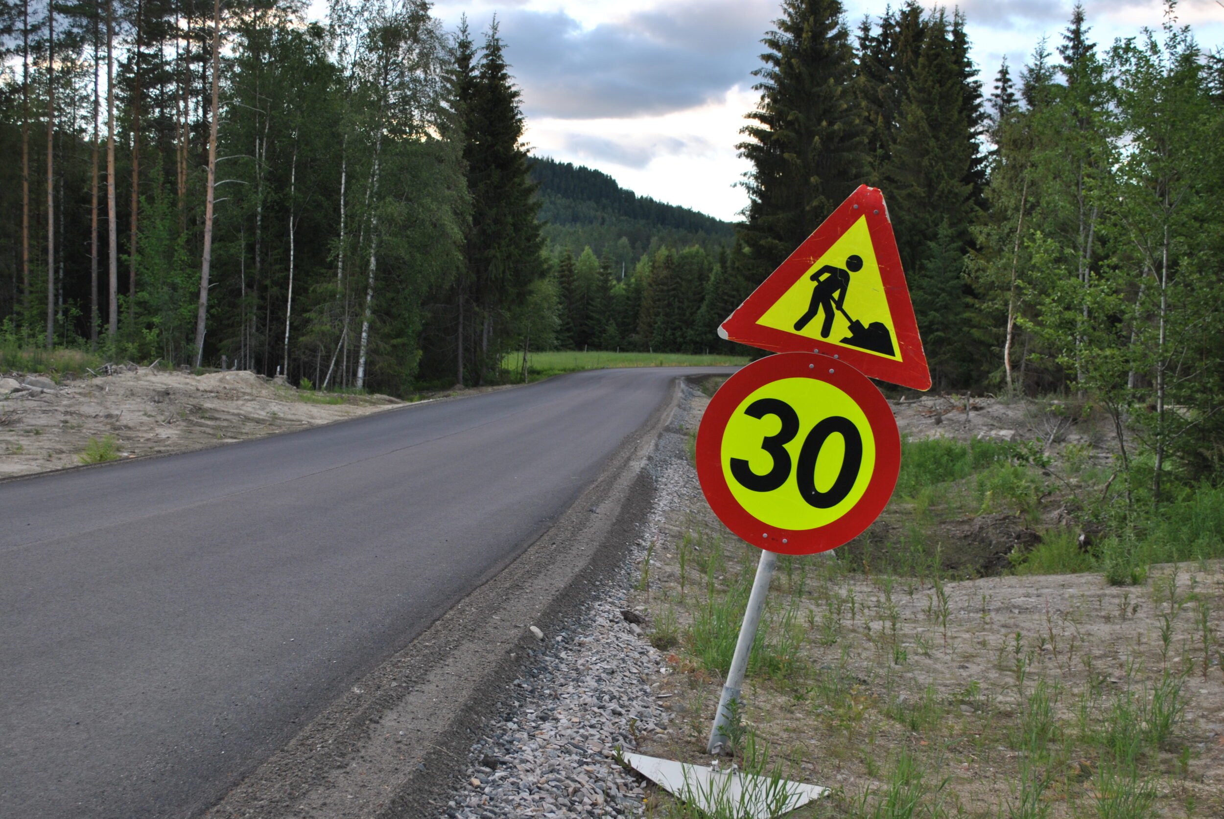 Bilde av en nyasfaltert vei med veiarbeid-skilt