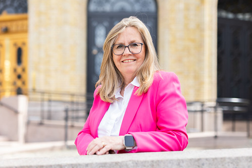 Tine Linnestad i rosa jakke foran Stortinget