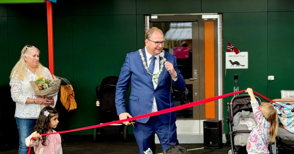 Christian Bendz klipper rød snor ved åpningen av Engelsrud barnehage. Foto: Nannestad kommune.