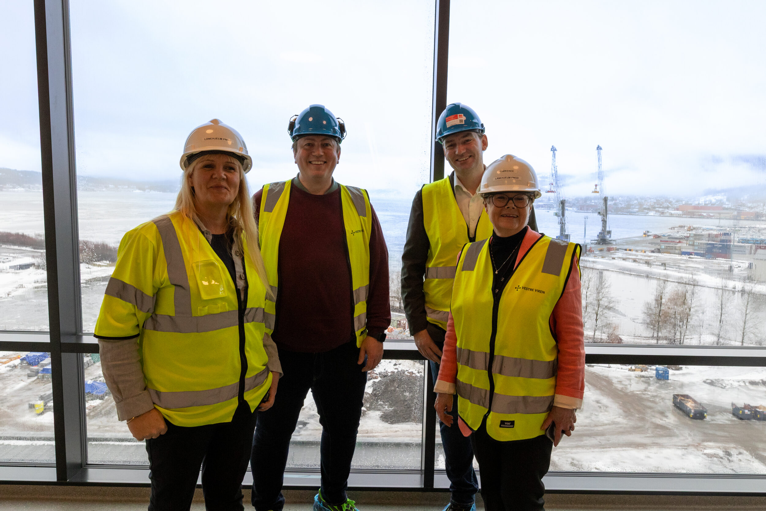 Kristin Surlien, Andreas Muri, Henrik Asheim og Kristin Ørmen Johsen foran utsikten utover Drammensfjorden fra det nye sykehuset.