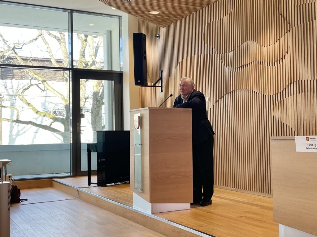 Lasse Berntzen på talerstolen i Fylkestinget 10. februar 2026 og Gumserød Gård